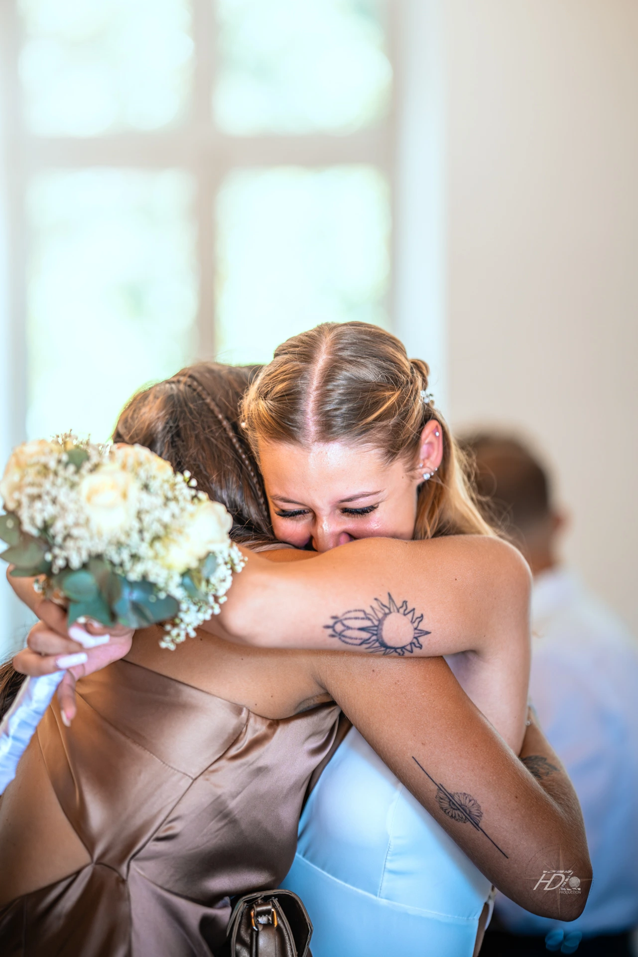 La mariée et sa demoiselle d'honneur se tenant dans les bras lors d'un moment d'émotion au mariage à côté de Bordeaux immortalisé par leur photographe mariage.