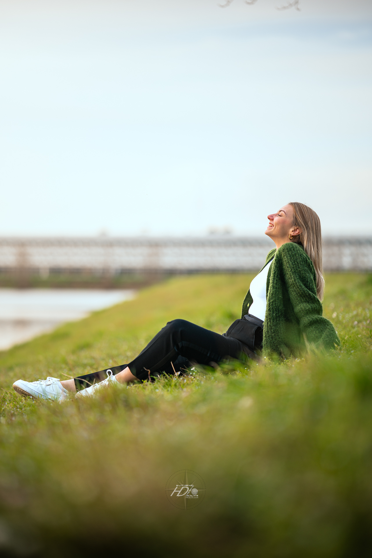 Une femme assise sur l'herbe lors d'une séance photo immortalisé par son photographe portrait à Bordeaux.