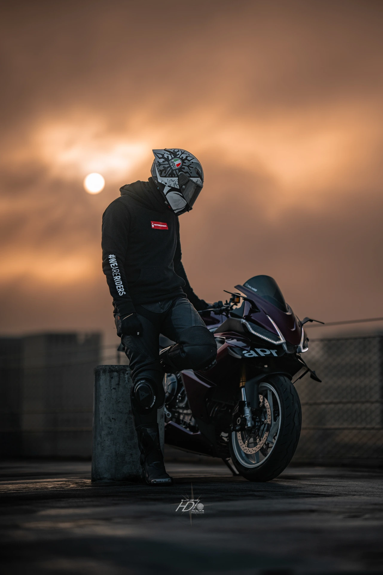 Un motard se fait prendre en photo avec le soleil caché derrière les nuages sombres.