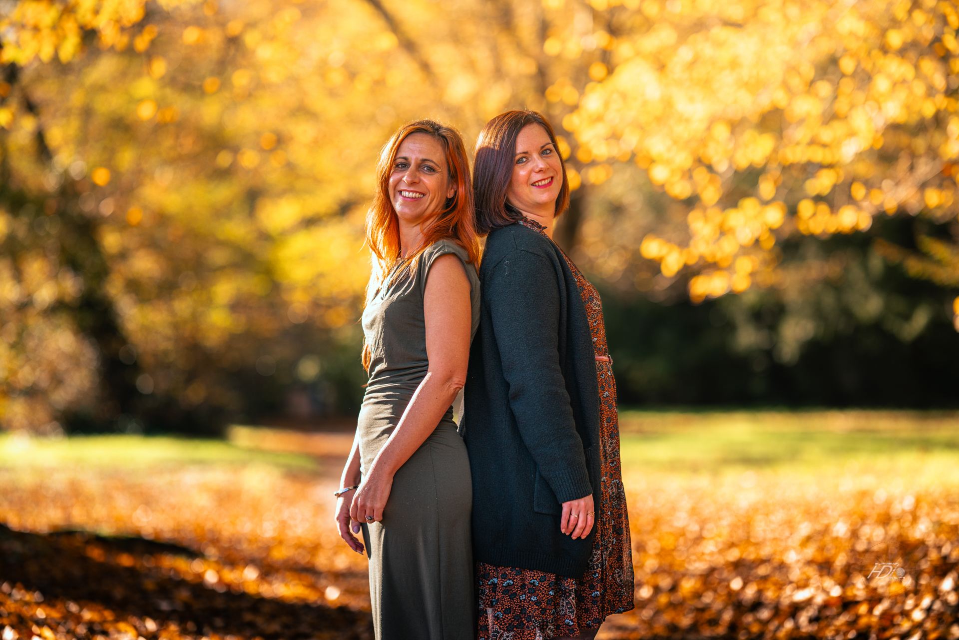 Deux soeurs se tenant dos à dos lors d'une séance photo immortalisé par leur photographe portrait à Bordeaux.