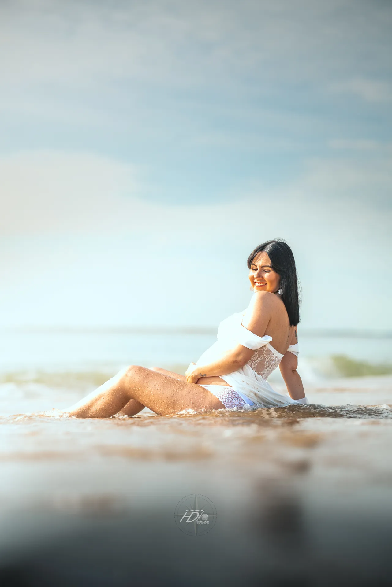 Un portrait d'une femme enceinte lors d'un shooting grossesse à la plage à côté de Bordeaux