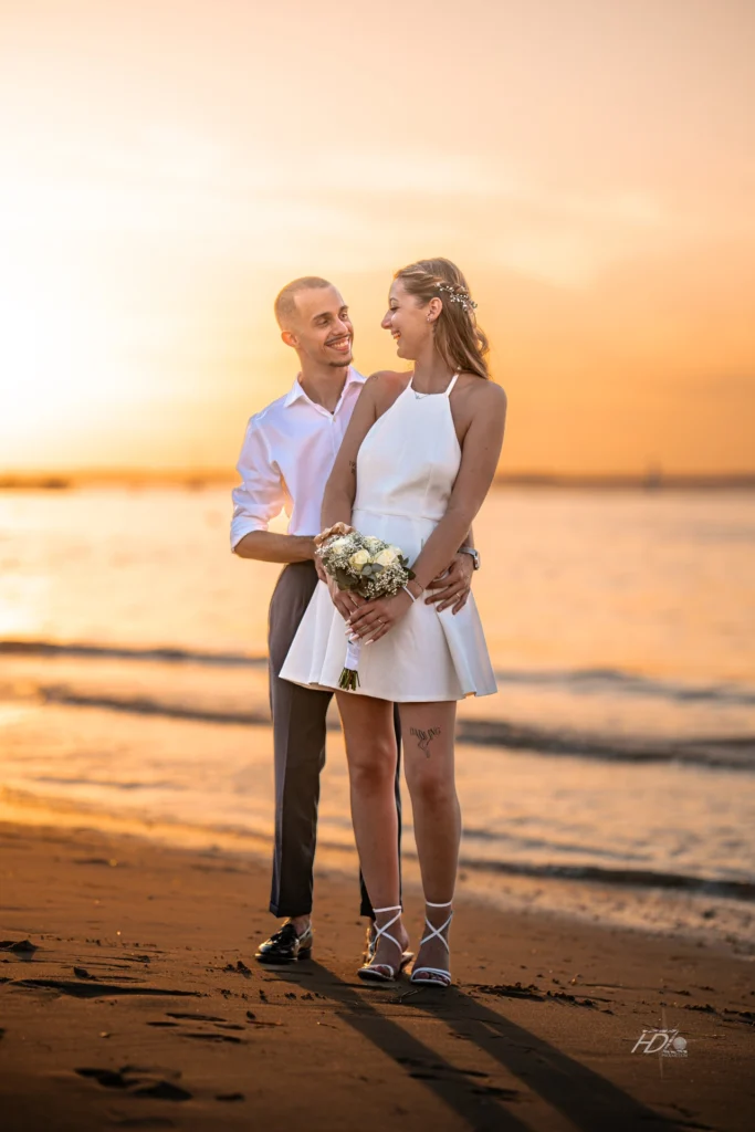 Un portrait des mariées à la plage à Arcachon lors de leur mariage immortalisé par leur photographe mariage.