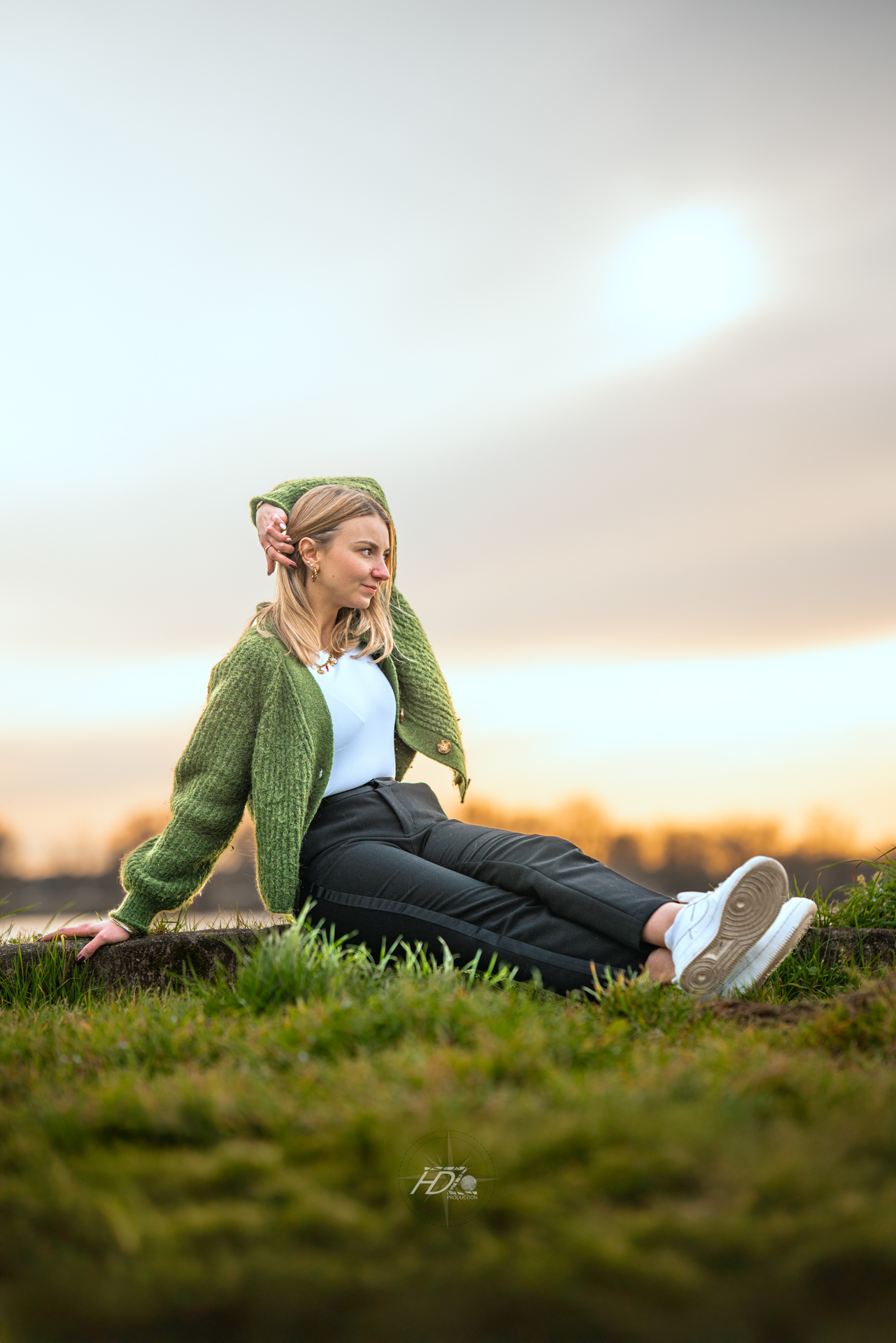 Une femme assise sur l'herbe lors d'une séance photo immortalisé par son photographe portrait à Bordeaux.