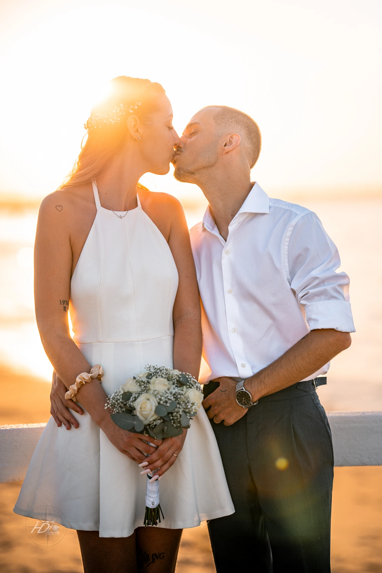 Les mariées s'embrassant avec le coucher de soleil à Arcachon lors de leur mariage immortalisé par leur photographe mariage.